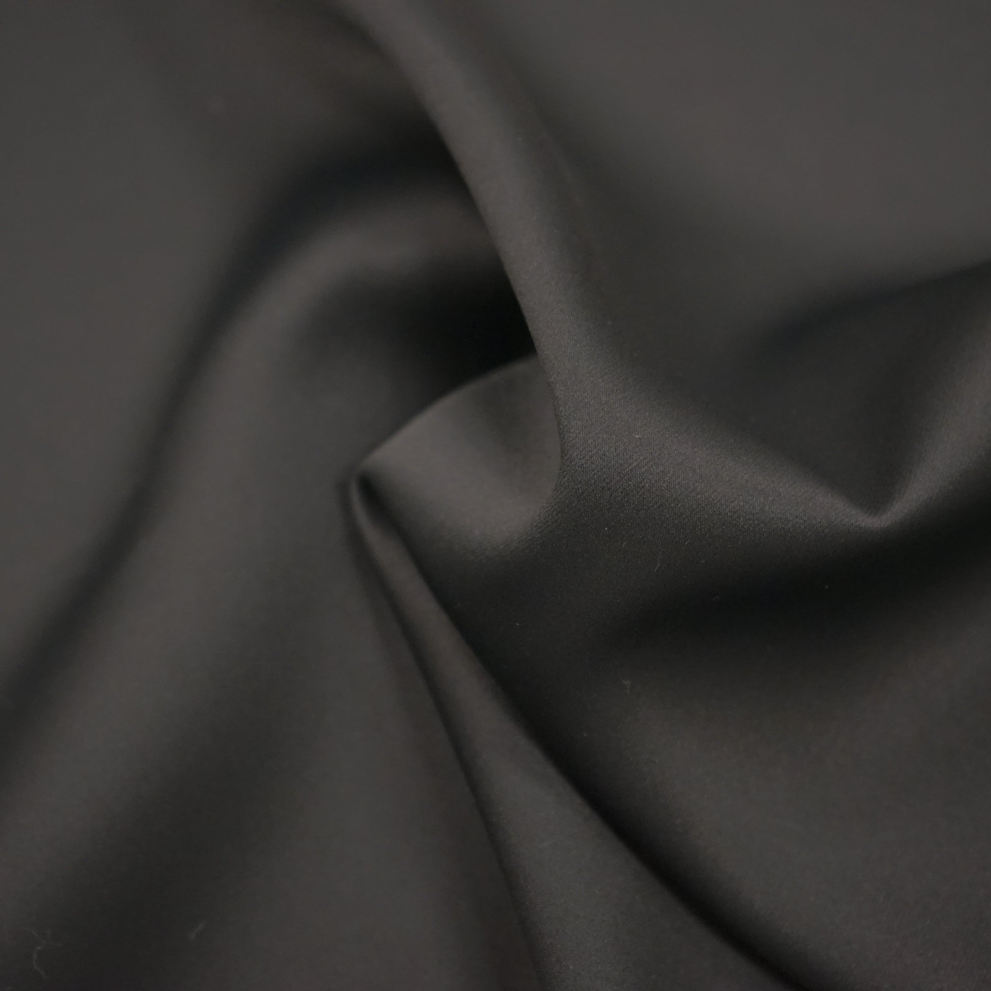 Plain black dimout lining fabric with a smooth drape.
