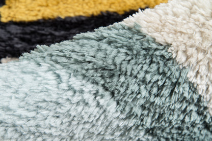Close-up of a shaggy retro rug (2' x 3') with teal, cream and yellow-black striped sections; plush, fluffy pile.