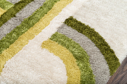 Shaggy retro rug with cream background and arc-shaped olive green, mustard yellow, and grey stripes.