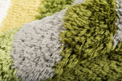 Close-up of a retro shag rug with olive green, gray, and mustard yellow fibers; soft, thick pile.