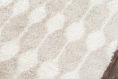 Taupe & ivory shag rug with plush pile & subtle geometric chevron pattern, wood floor edge visible.