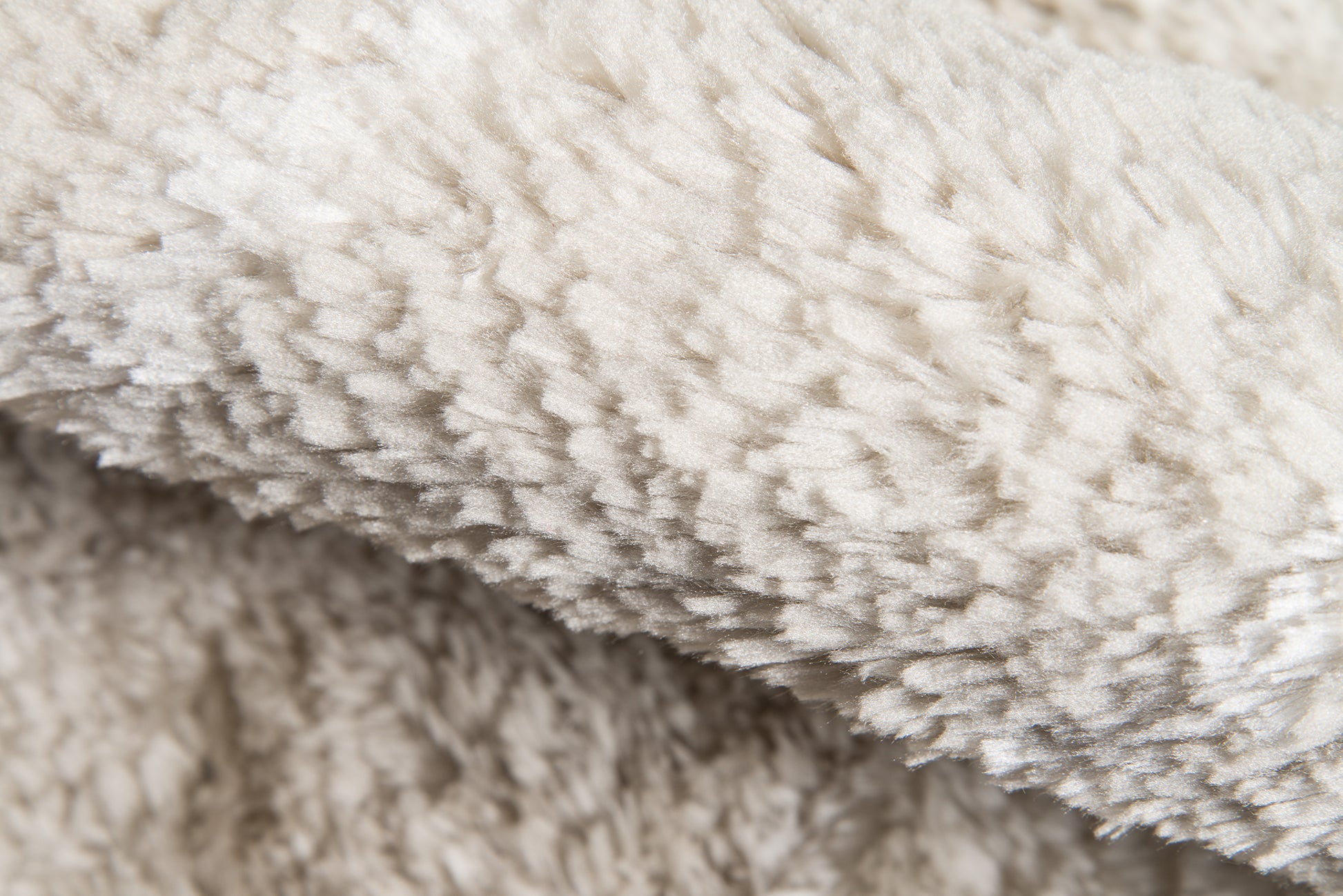Taupe area rug close-up with plush sherpa texture.