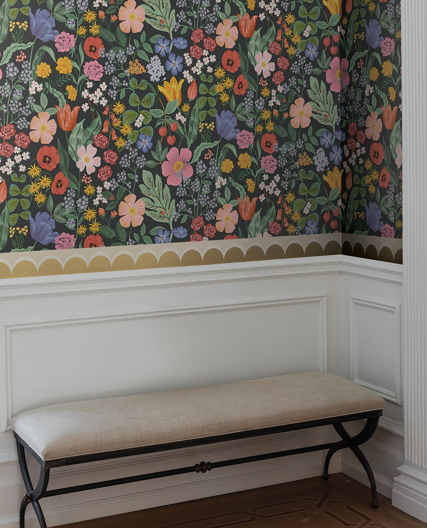 Yellow geometric linen scallop wallpaper trim on wall with white wainscoting and beige cushioned bench.