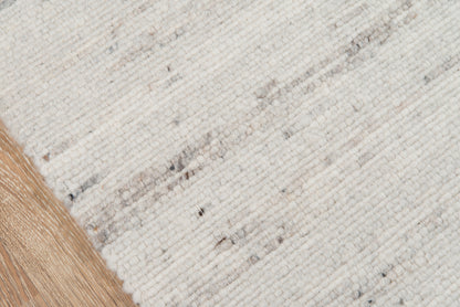 Cream ivory woven rug with subtle gray flecks and a light tan fringe along the edge.