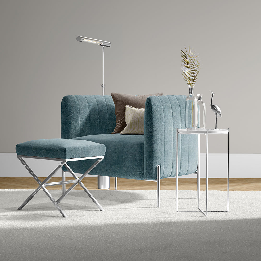 Teal velvet lounge chair with matching ottoman, chrome legs, modern living set with glass-top side tables & decor.