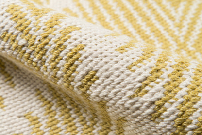 Close-up of yellow and cream striped rug with chunky yarn and rolled edge.