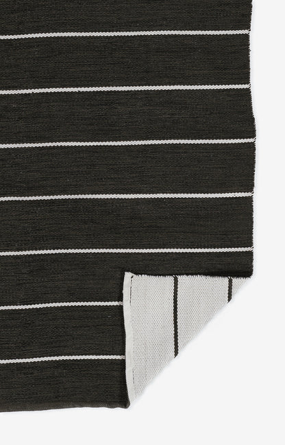Dark charcoal knit with thin white horizontal stripes; folded edge reveals light inner fabric with vertical black lines.