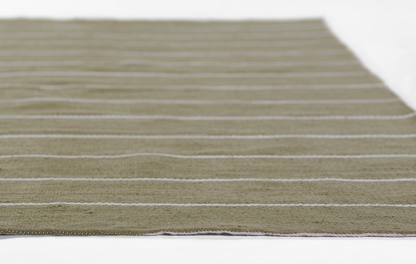 Rectangular olive-green flat-weave rug with thin cream stripes; casual coastal-style decor.