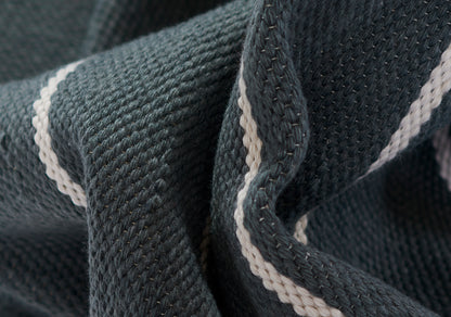 Close-up of dark navy ribbed knit fabric with a white piping stripe along the edge