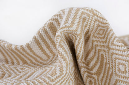 Beige and cream geometric woven throw blanket with diamond motif, soft textured fabric.
