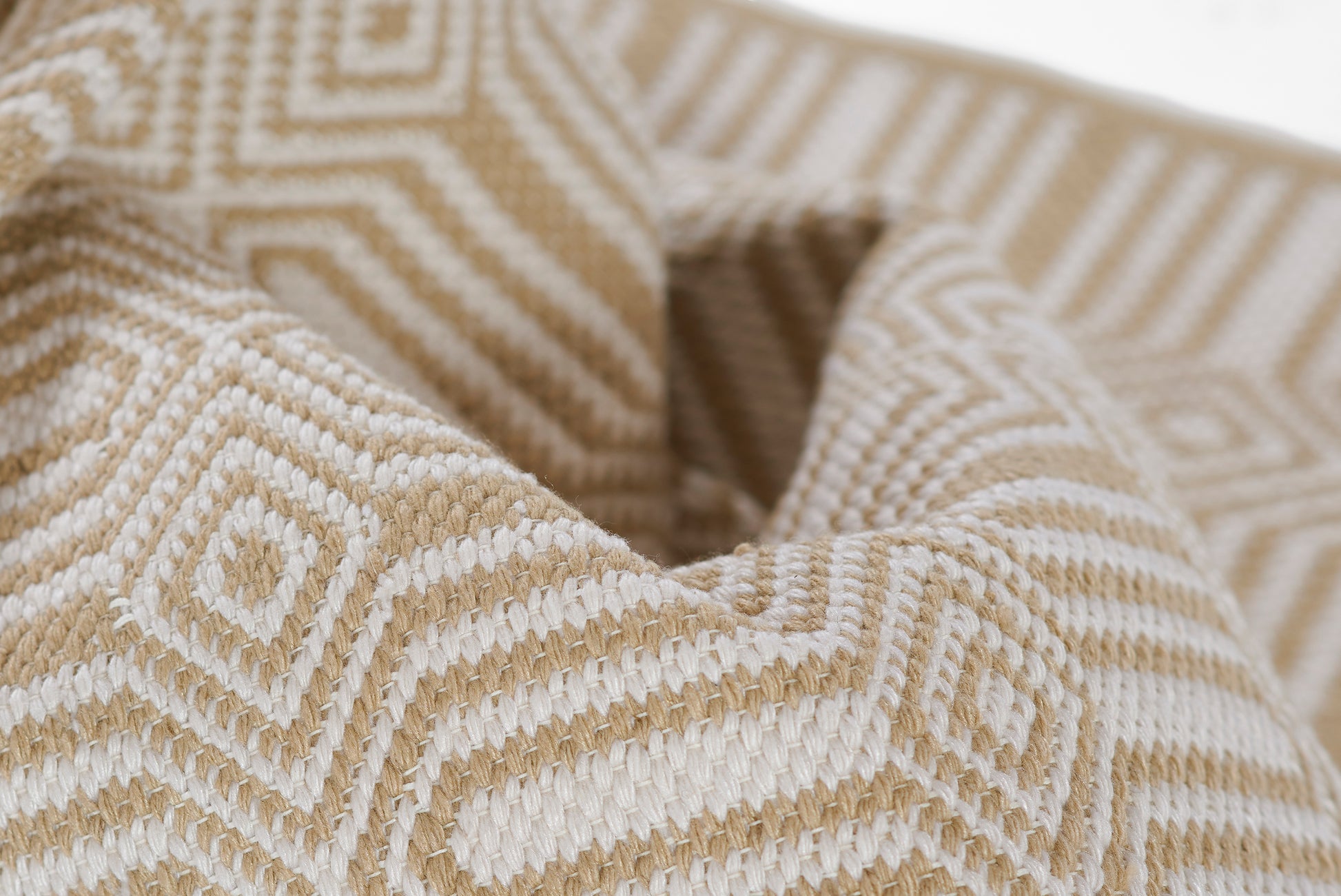 Beige and white geometric diamond pattern woven fabric with thick texture; ideal as a rug or throw.
