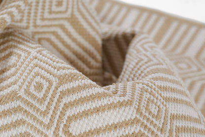 Beige and ivory geometric woven cotton rug with a textured surface.