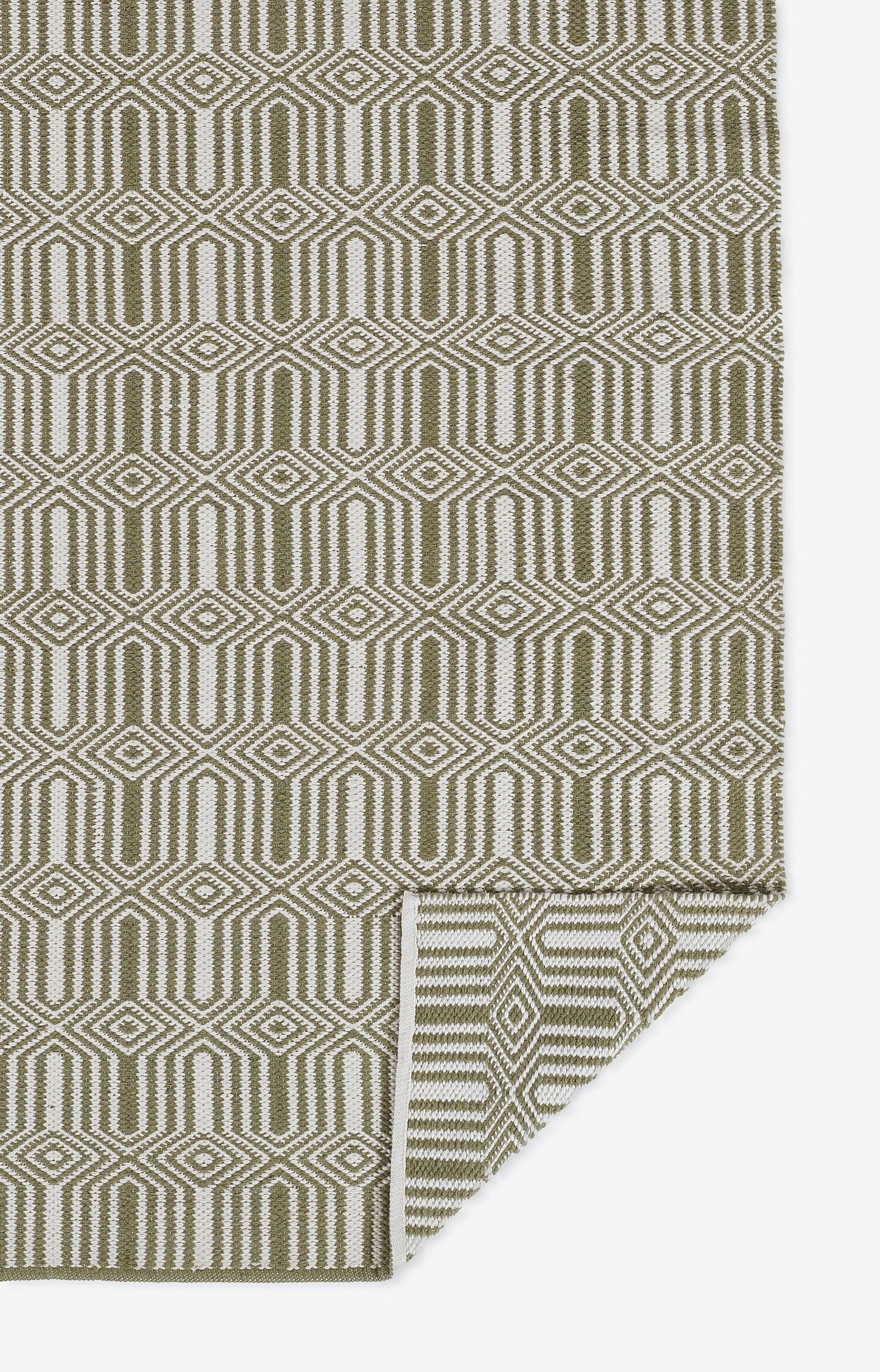 Olive green and cream geometric rug with interlocking diamond shapes; folded corner.