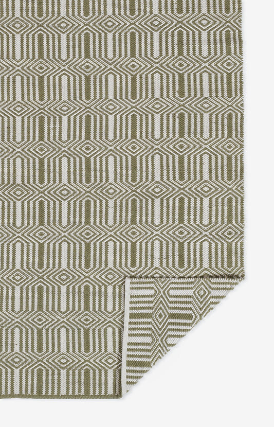 Olive green and cream geometric rug with interlocking diamond pattern; folded corner reveals the reverse.