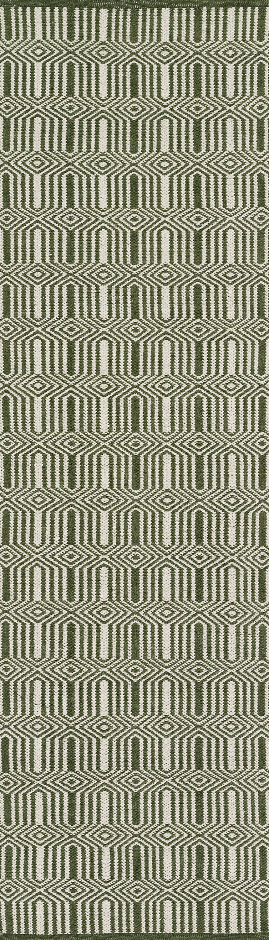 Olive green woven rug with cream geometric diamond/hex pattern.