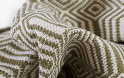 Olive green and ivory rug with a geometric diamond pattern; soft, cozy home decor.