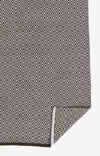 Brown and cream diamond lattice woven rug, rectangular with folded corner, 2' x 3'.