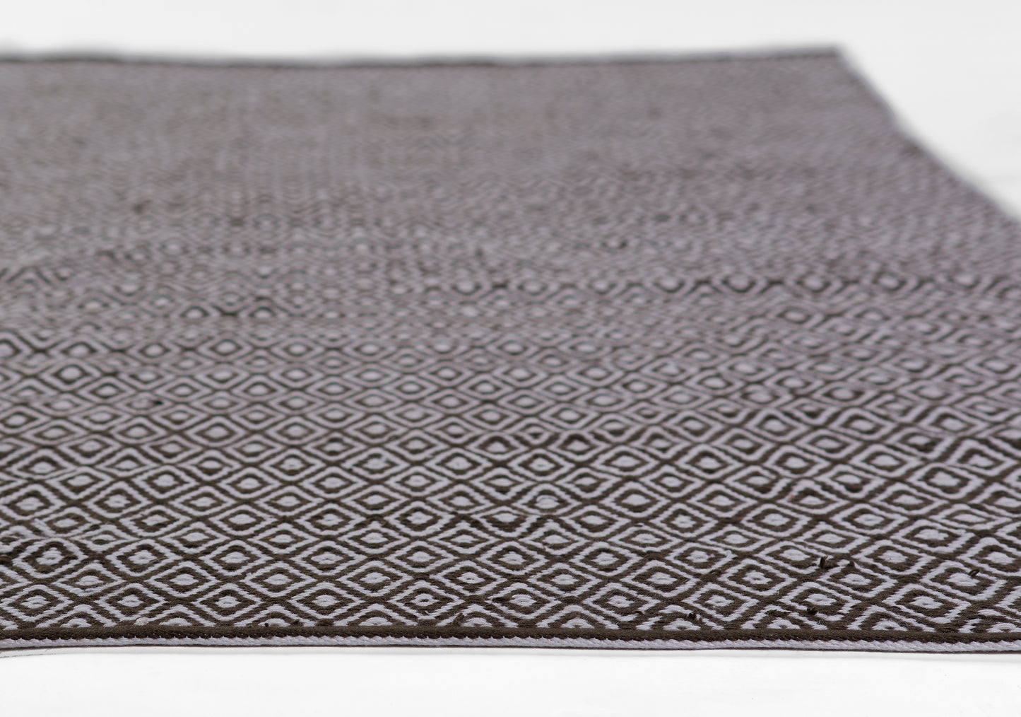 Rectangular brown woven rug with a repeating white diamond pattern.