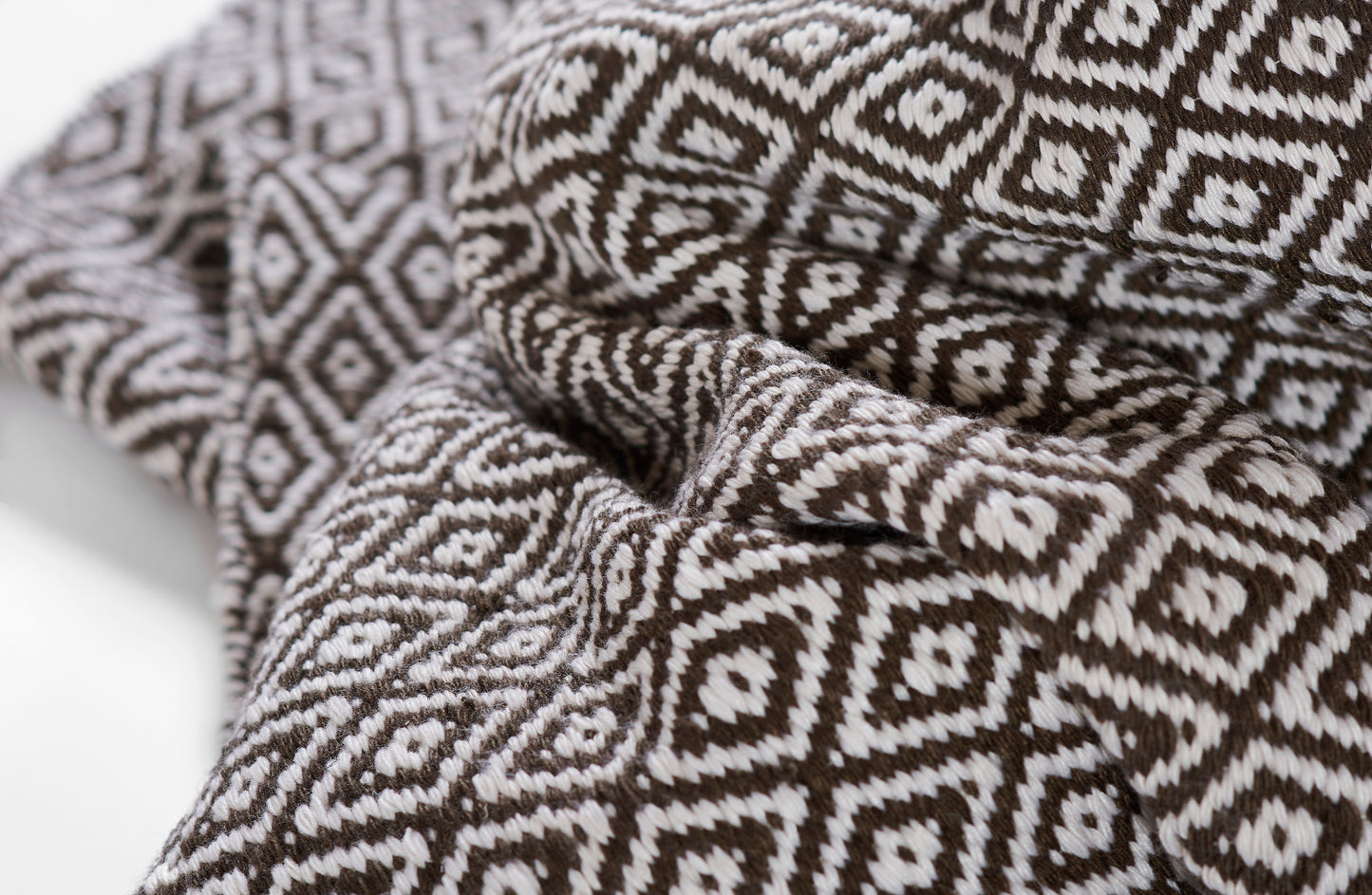 Brown and white geometric diamond-pattern rug, soft and woven.