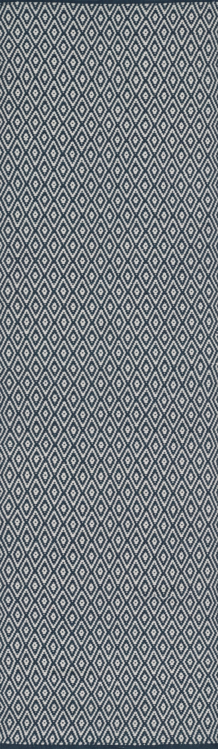 Navy rug with a repeating white diamond lattice pattern; 4' x 6'.