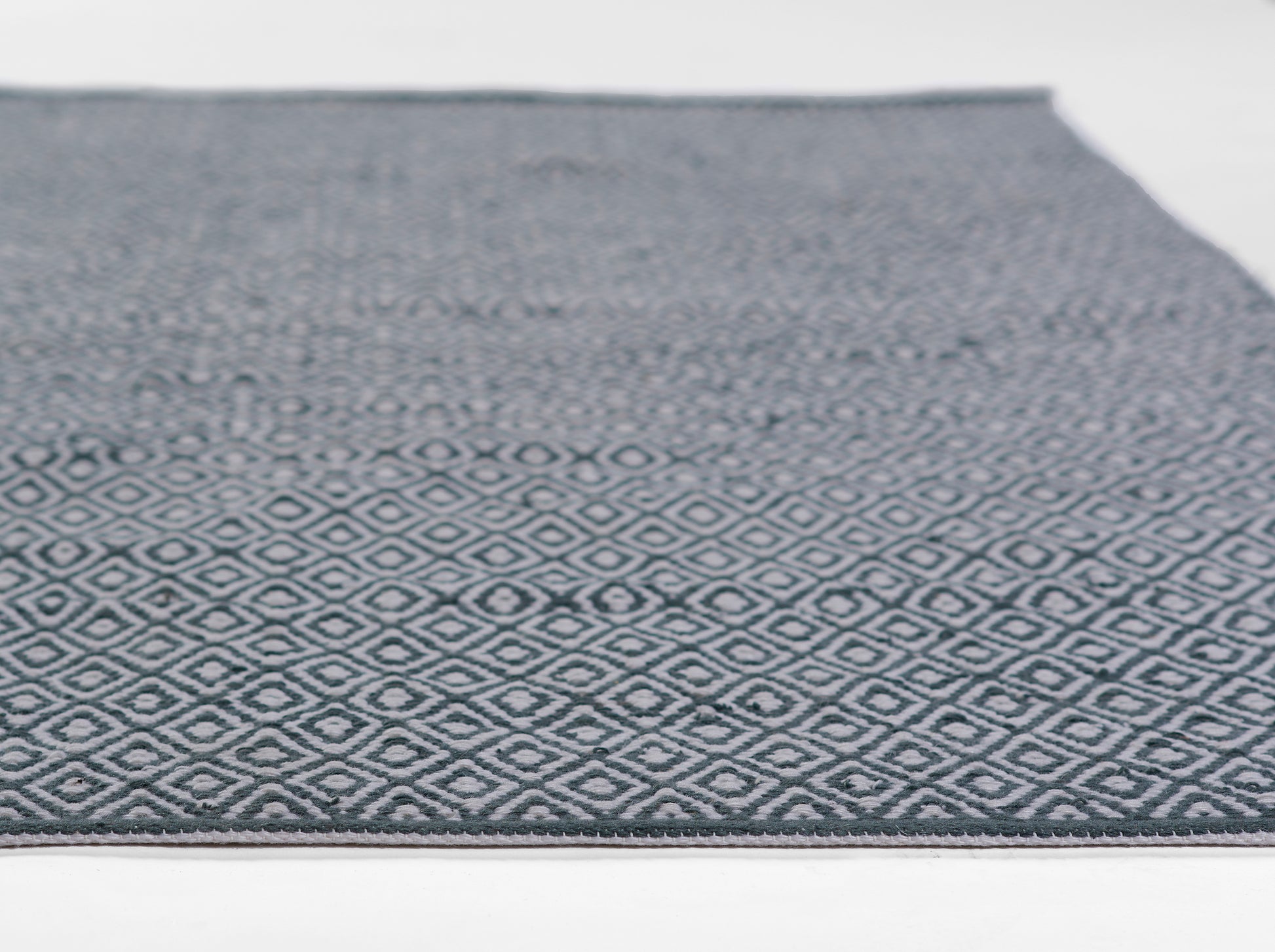 Blue-gray flat-weave rug with a white diamond lattice pattern; rectangular hallway piece.