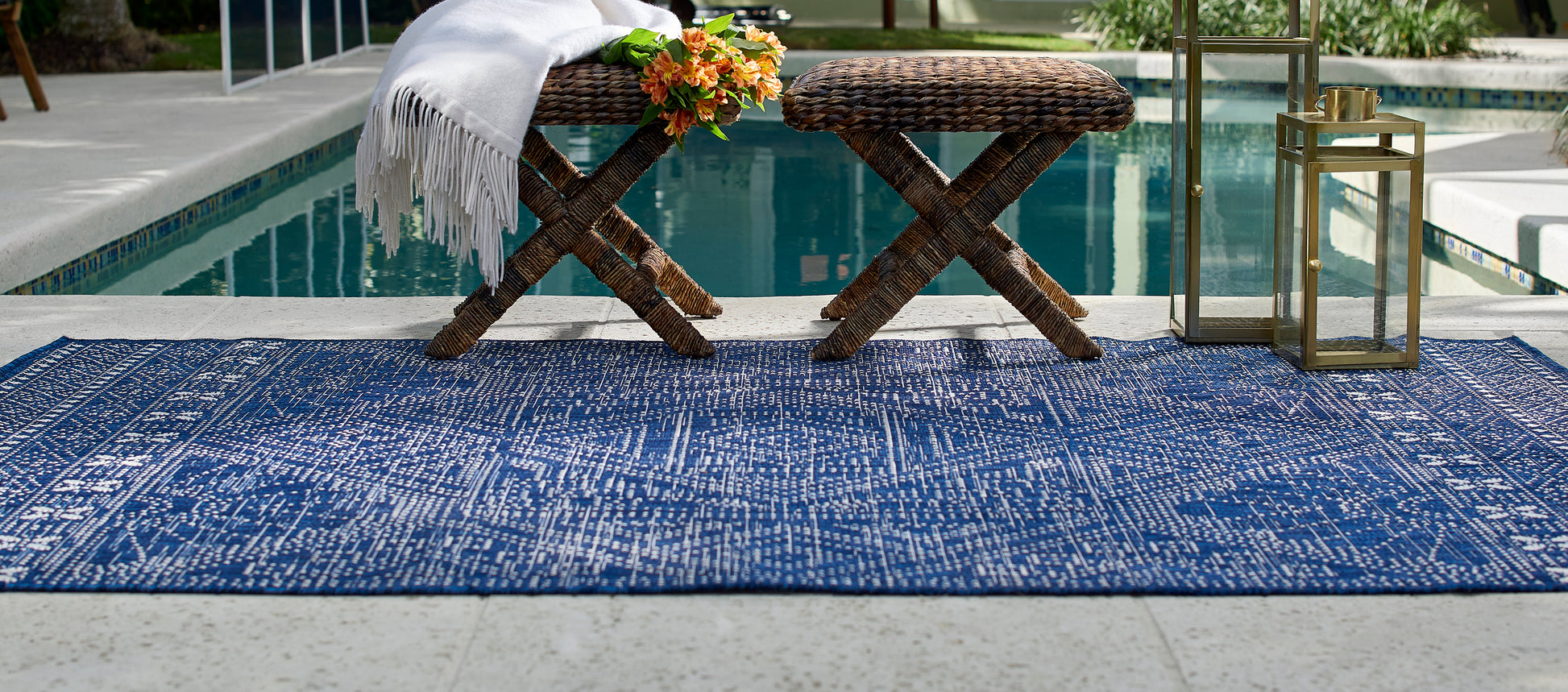 Navy blue distressed outdoor rug on poolside concrete.