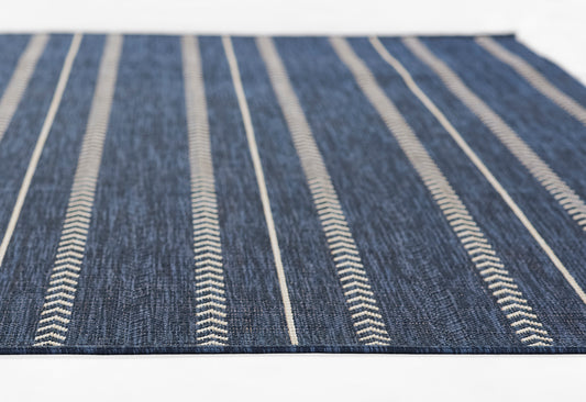 Denim blue flat-weave rug with narrow white stripes running lengthwise; casual home decor.