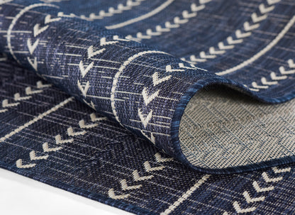 Denim blue woven rug with white chevron stripes and rolled edge.