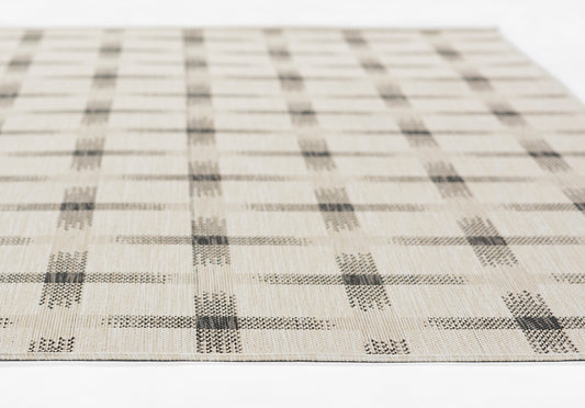 Beige woven rug with gray square grid plaid pattern, flat lay, textured surface.