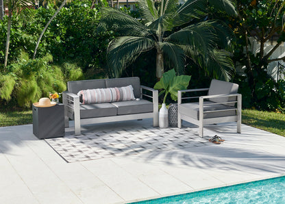 Grey outdoor rug, 7' x 9', with a geometric pattern by a pool.