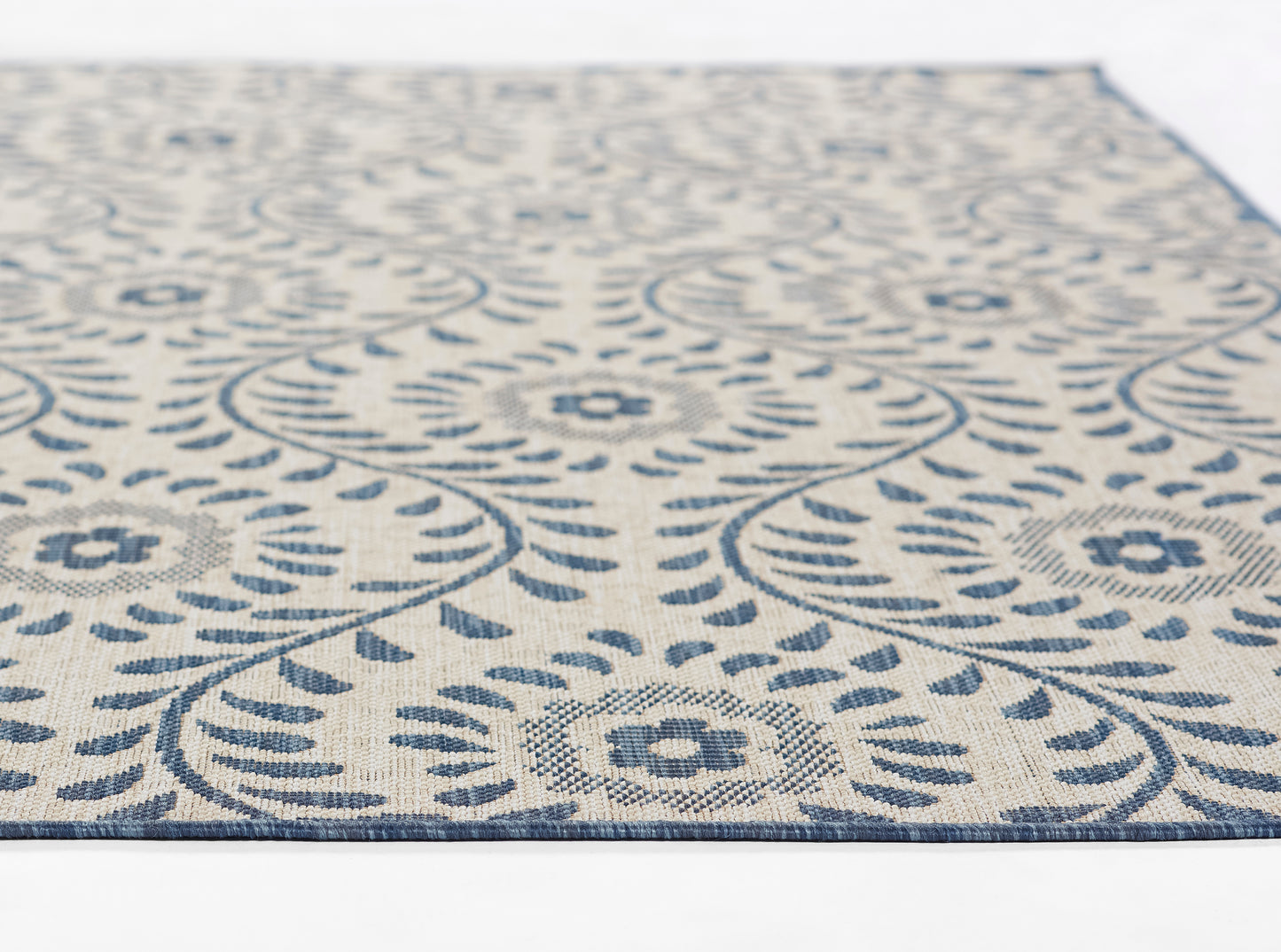 Blue and ivory patterned rectangular rug with circular floral medallions and decorative border, woven texture.