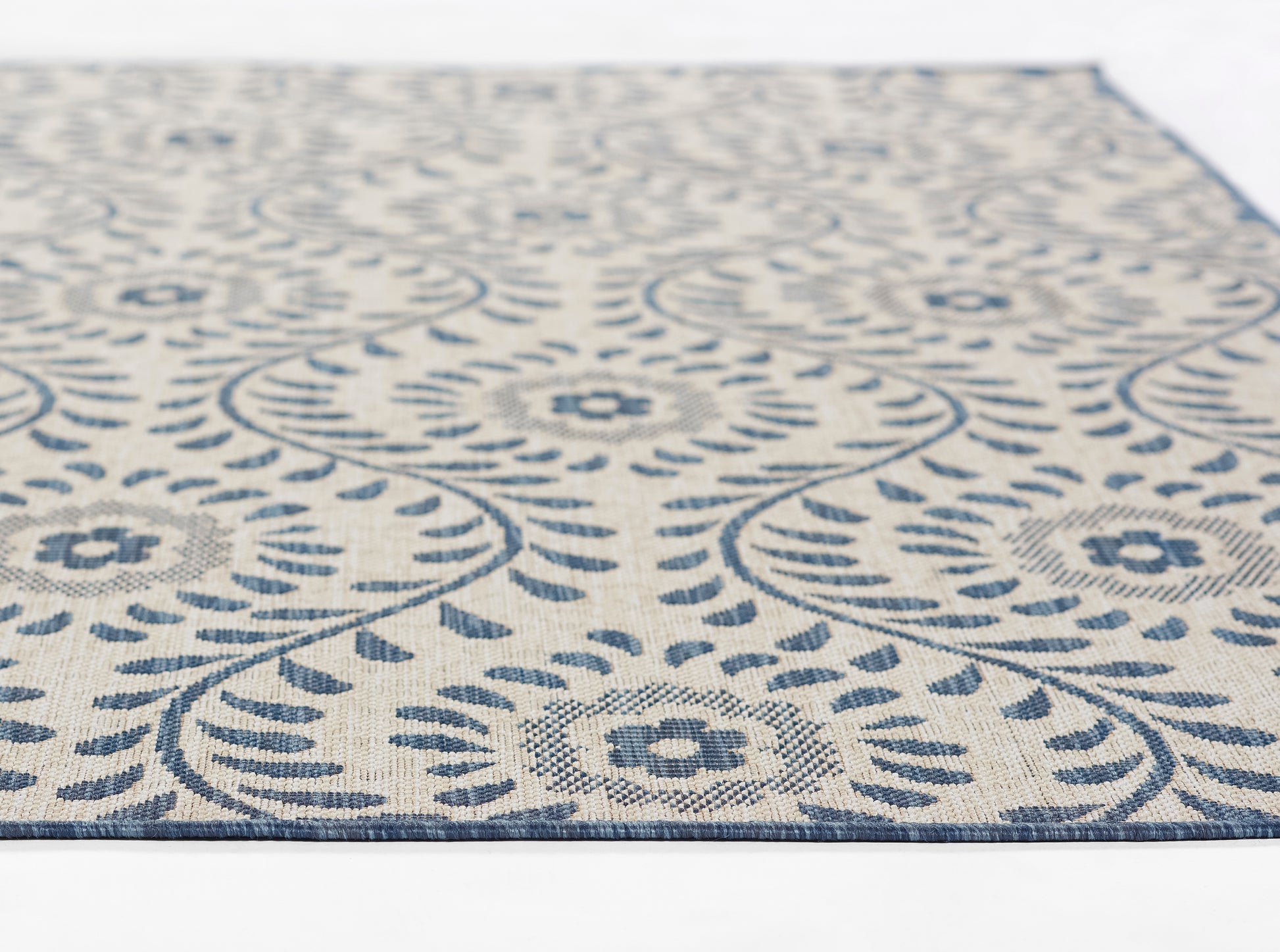 Blue and ivory patterned rectangular rug with circular floral medallions and decorative border, woven texture.
