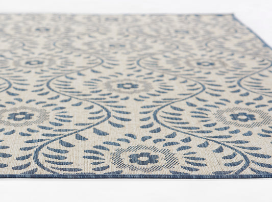 Blue and ivory patterned rectangular rug with circular floral medallions and decorative border, woven texture.