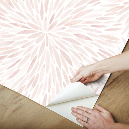 Soft pink and white radial leaf wallpaper being peeled back; modern pastel wall decor.