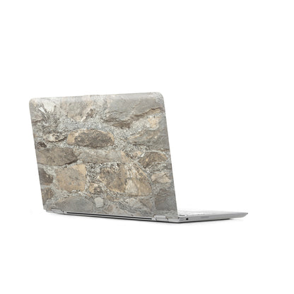 Close-up of weathered stone almond peel-and-stick wallpaper with a gray stone texture.