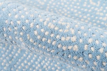 Close-up of light blue plush microfiber fabric with white raised dot pattern, soft and cozy.