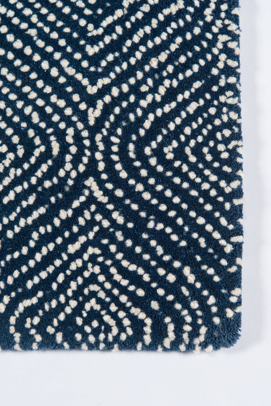 Shaggy navy rug with white dotted chevron geometric pattern and plush tufted texture; modern floor decor.