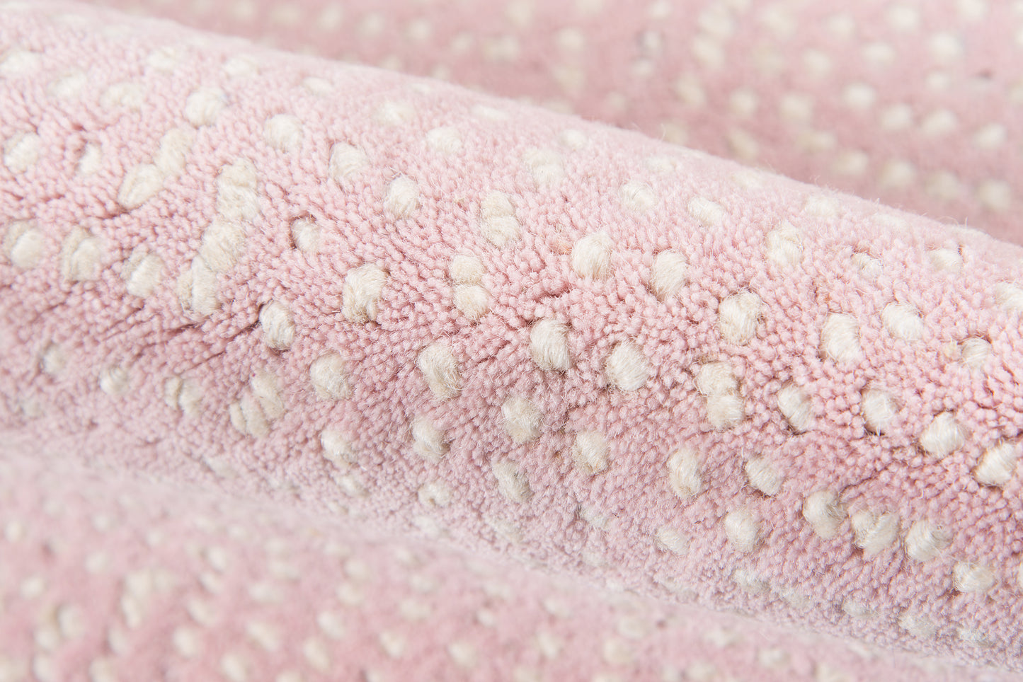 Soft pink plush boucle fabric with white raised dot pattern; cozy, textured textile.