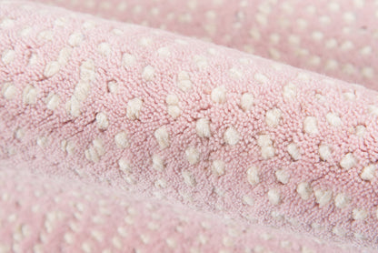 Soft pink plush boucle fabric with white raised dot pattern; cozy, textured textile.
