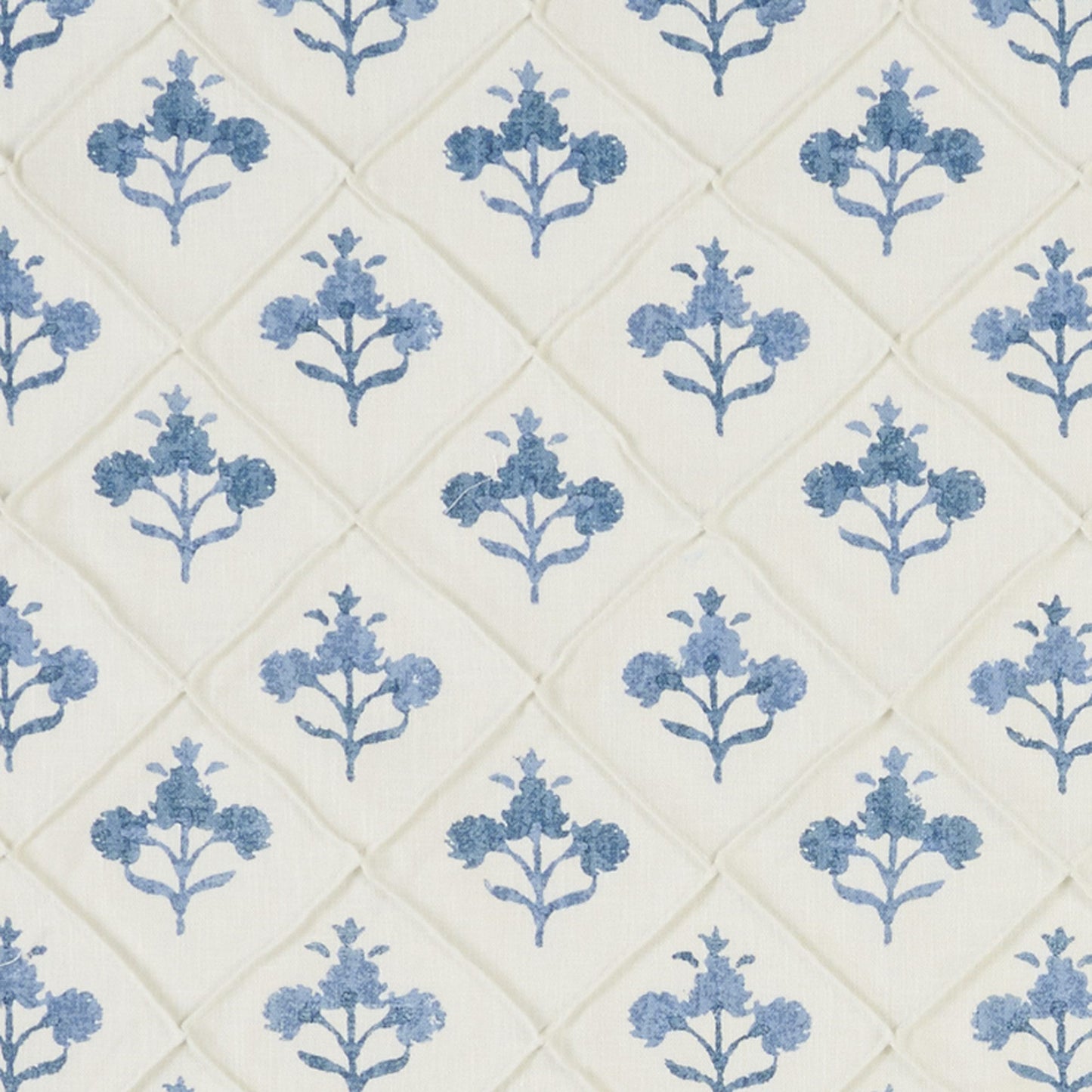 Quilted fabric with blue floral motifs in a diamond lattice pattern; ideal for bedding or upholstery.