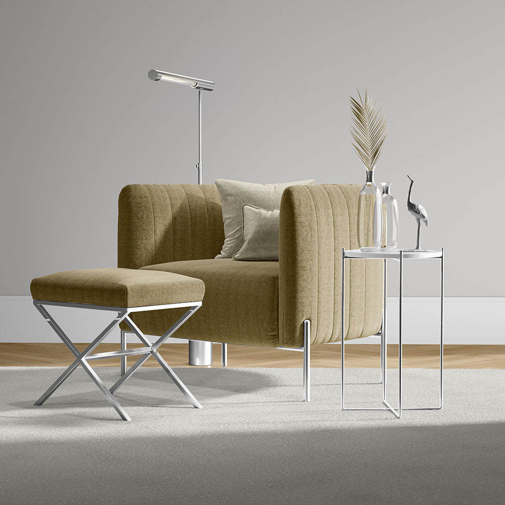 Sand solid fabric curved sofa with a matching ottoman, chrome legs, and glass-topped side tables beside a modern floor lamp.
