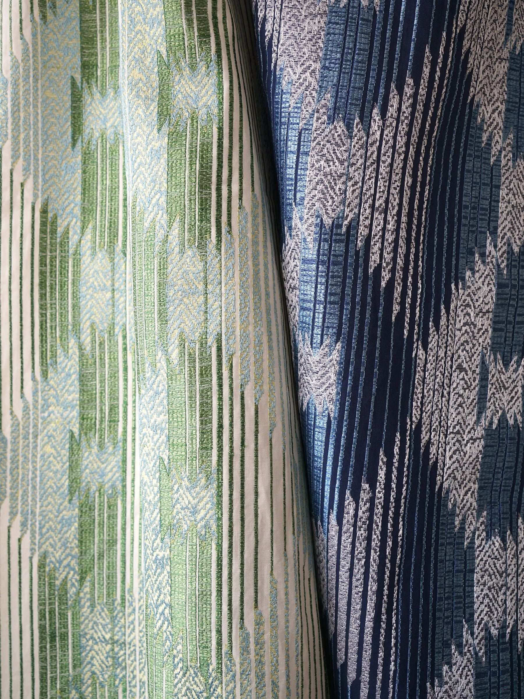 Two-tone woven blanket fabric with vertical chevrons; green & light blue left, navy & light blue right; textured jacquard.