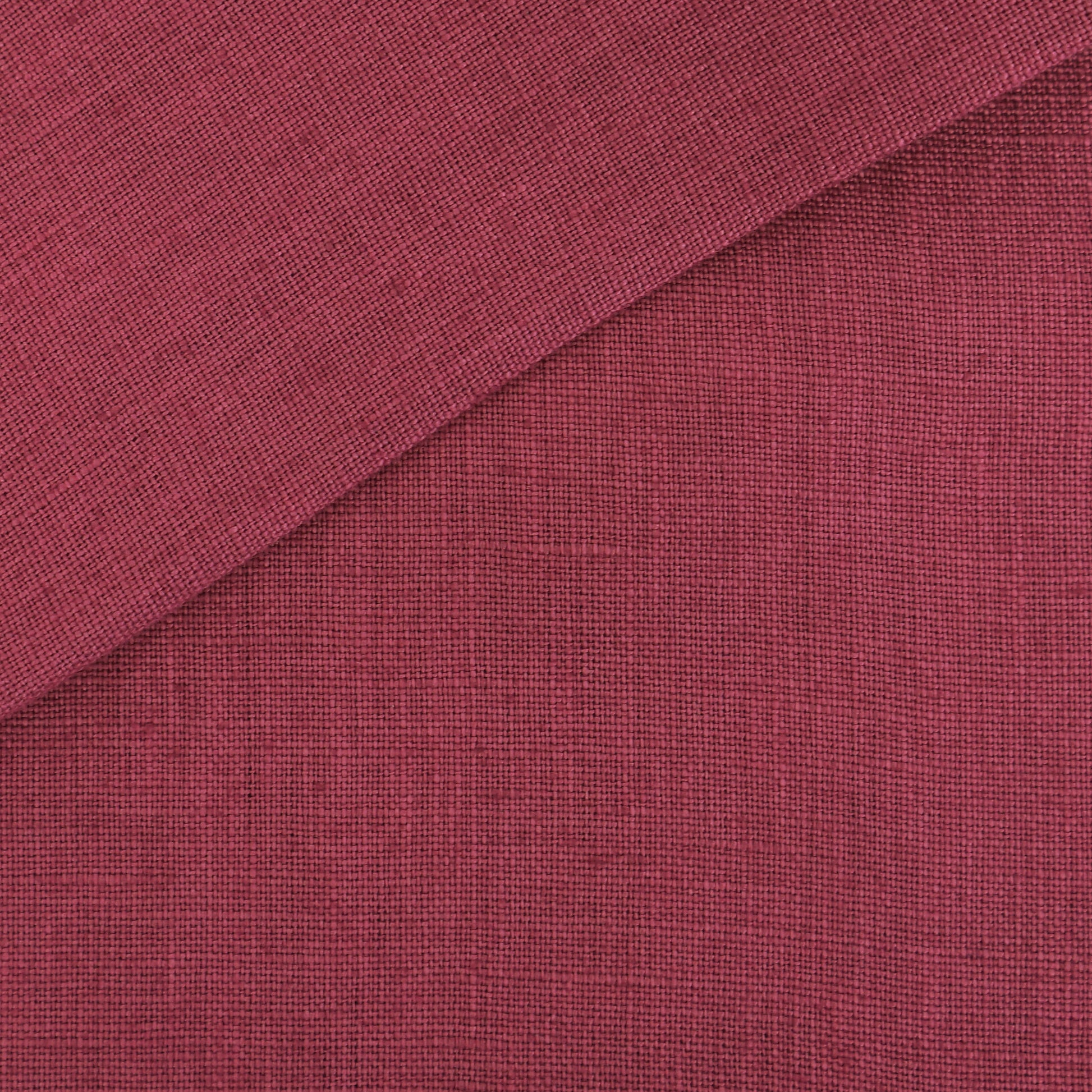 Pink linen-look fabric swatch with a folded diagonal corner and a textured weave.