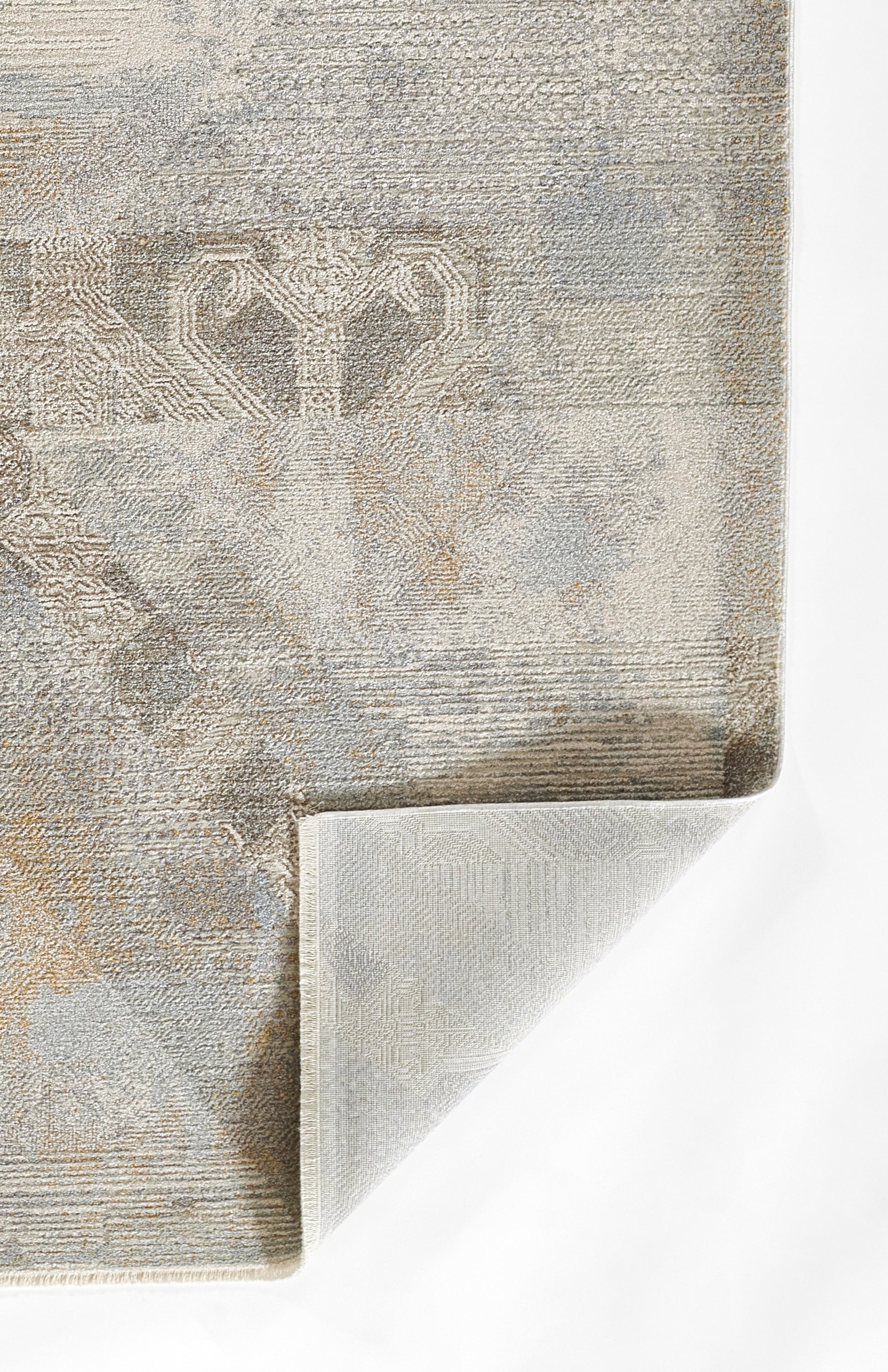 Bluish-gray woven area rug with subtle damask pattern; folded corner shows the light backing.