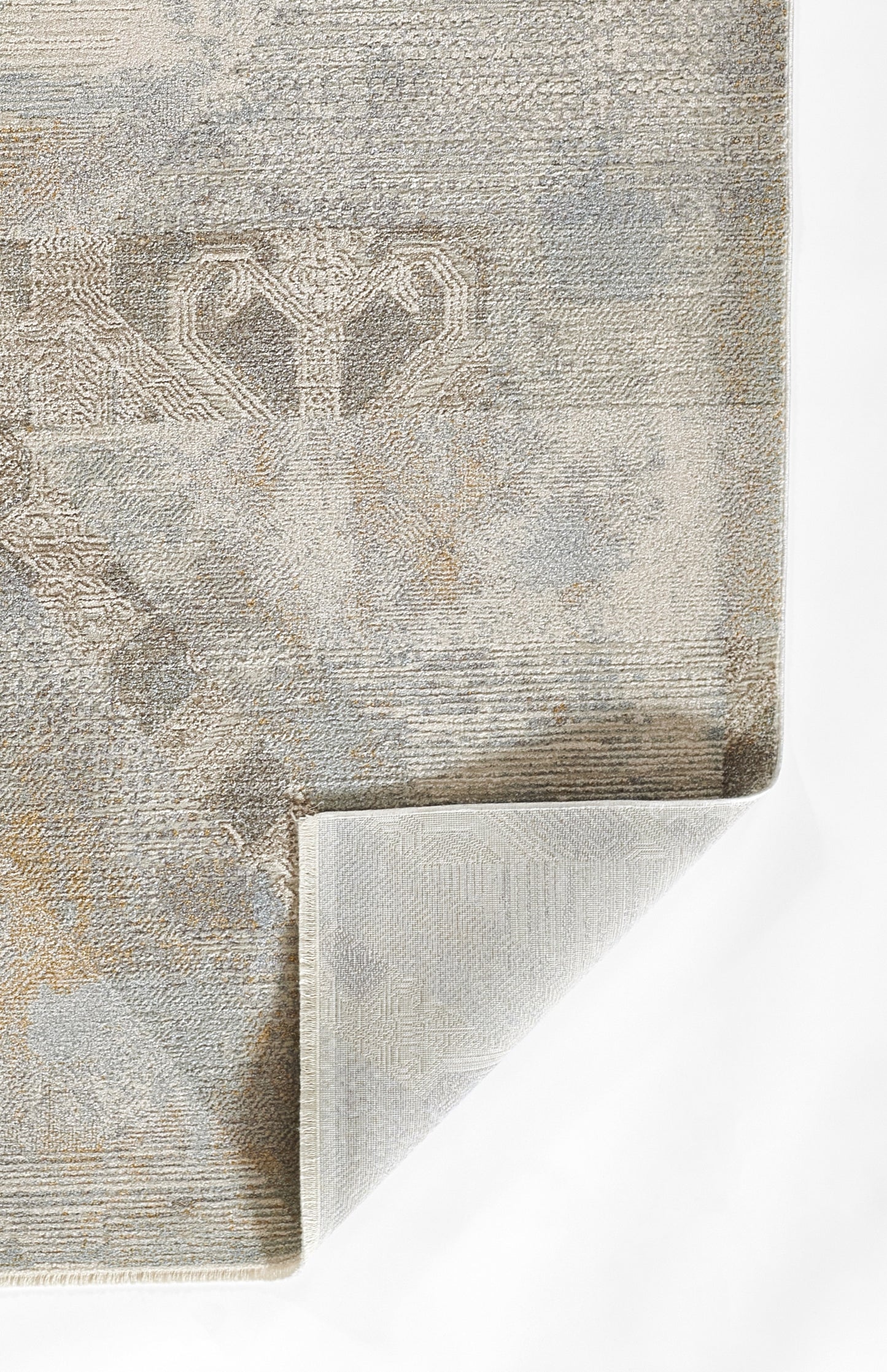 beige-gray patterned rug with damask motif, textured weave, folded corner showing light backing