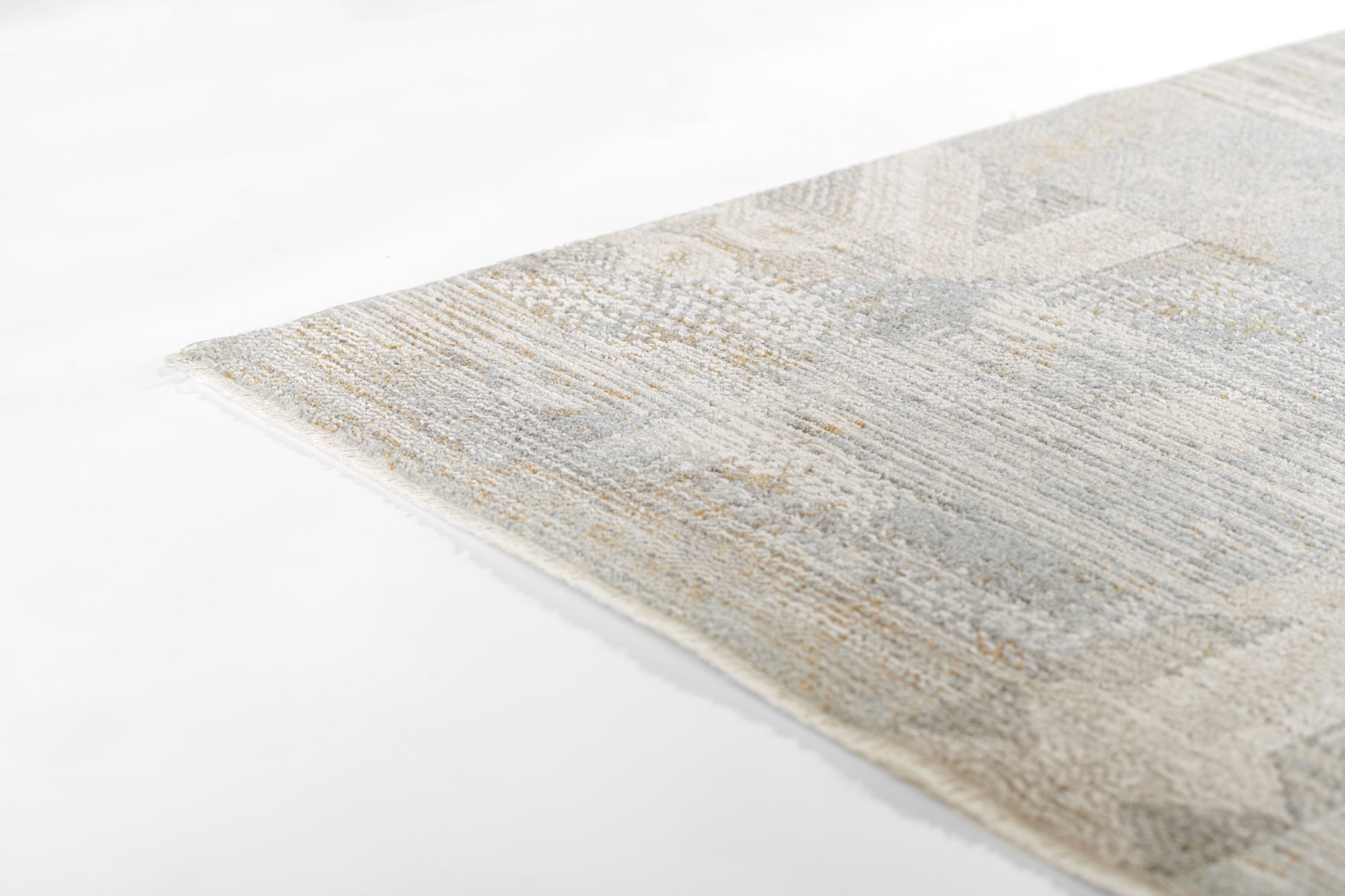Beige and blue geometric woven rug with a soft textured pile; close-up corner view.