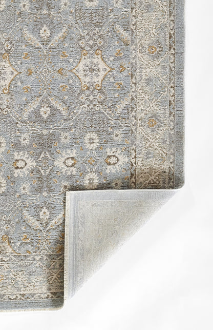 Blue-gray oriental rug with beige and gold accents, ornate pattern; curled corner reveals soft backing.