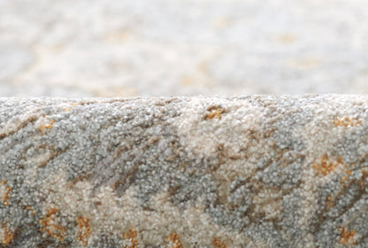 Blue-gray boucle rug close-up with orange flecks and soft textured pile.