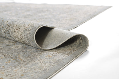 Bluish-gray textured runner rug with a marbled pattern; rolled corner reveals light underside and bound edges.