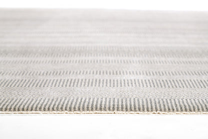 Close-up of a gray and off-white striped flat-weave rug with a light tan edge.